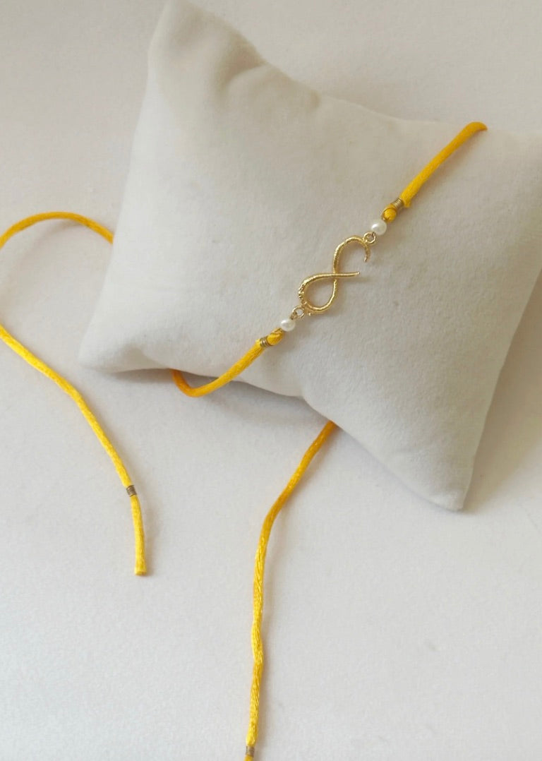 SMALL INFINITY RAKHI GOLD AND SAFFRON PEARLS