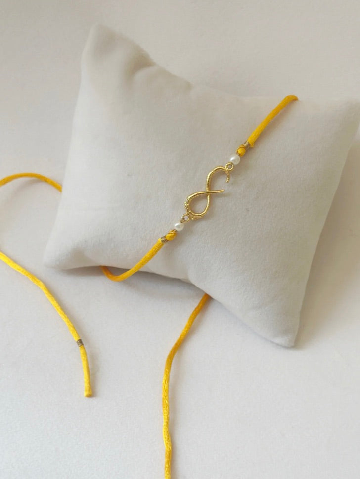 SMALL INFINITY RAKHI GOLD AND SAFFRON PEARLS